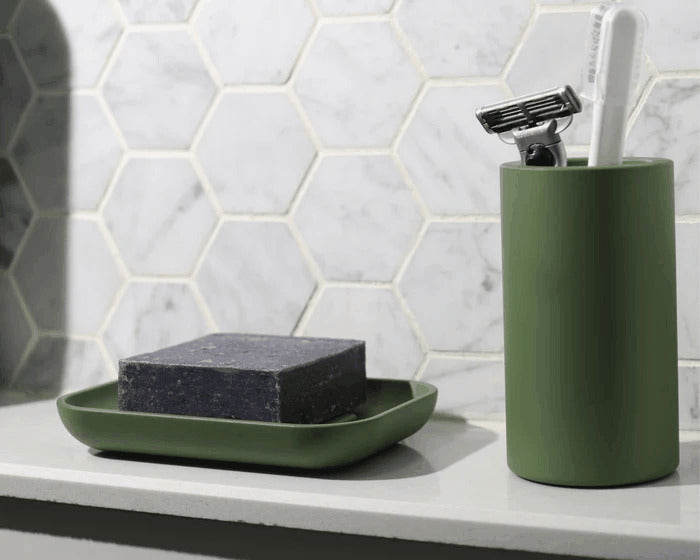 Modern green soap dish and holder on marble backsplash, adding a clean, stylish touch to a minimalist bathroom decor.