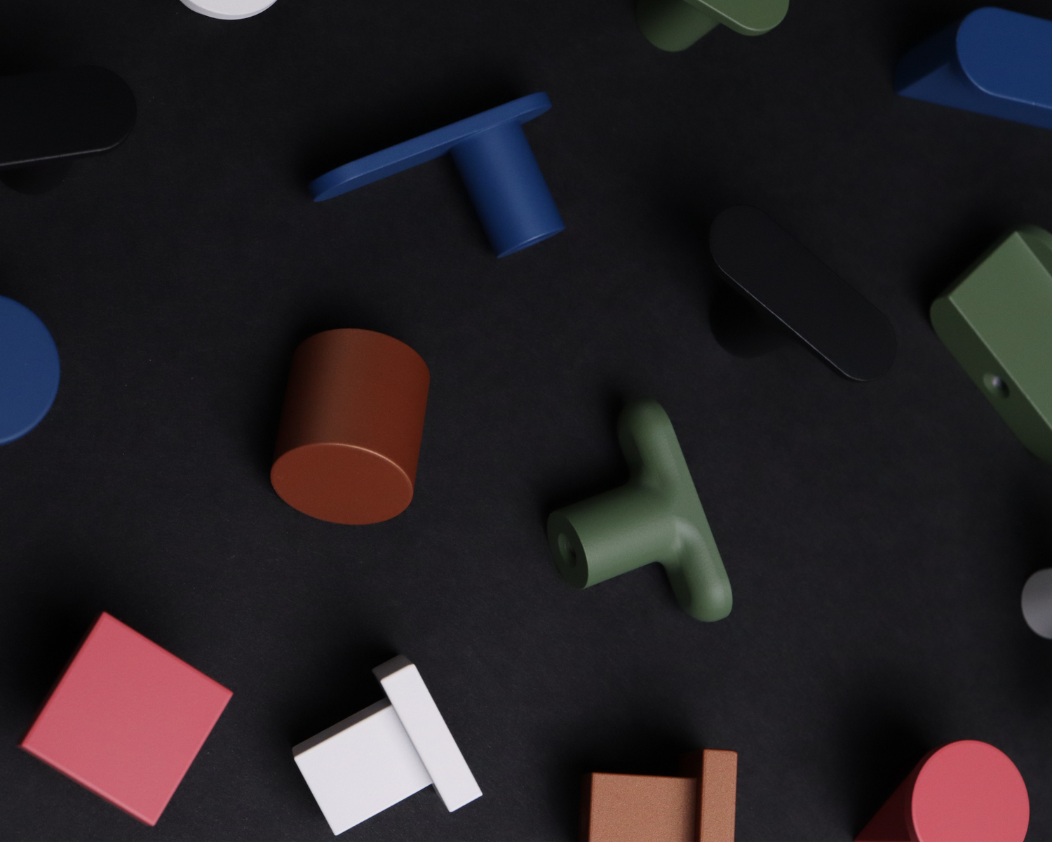 Colorful matte cabinet knobs and pulls in bold shapes on a black background, showcasing ROUS’s vibrant hardware collection.