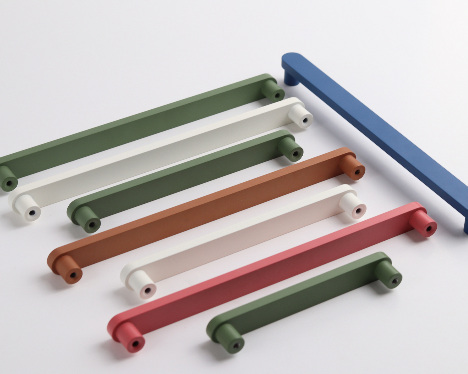 Modern cabinet handles in assorted colors and styles displayed on a white surface for kitchen and furniture use.