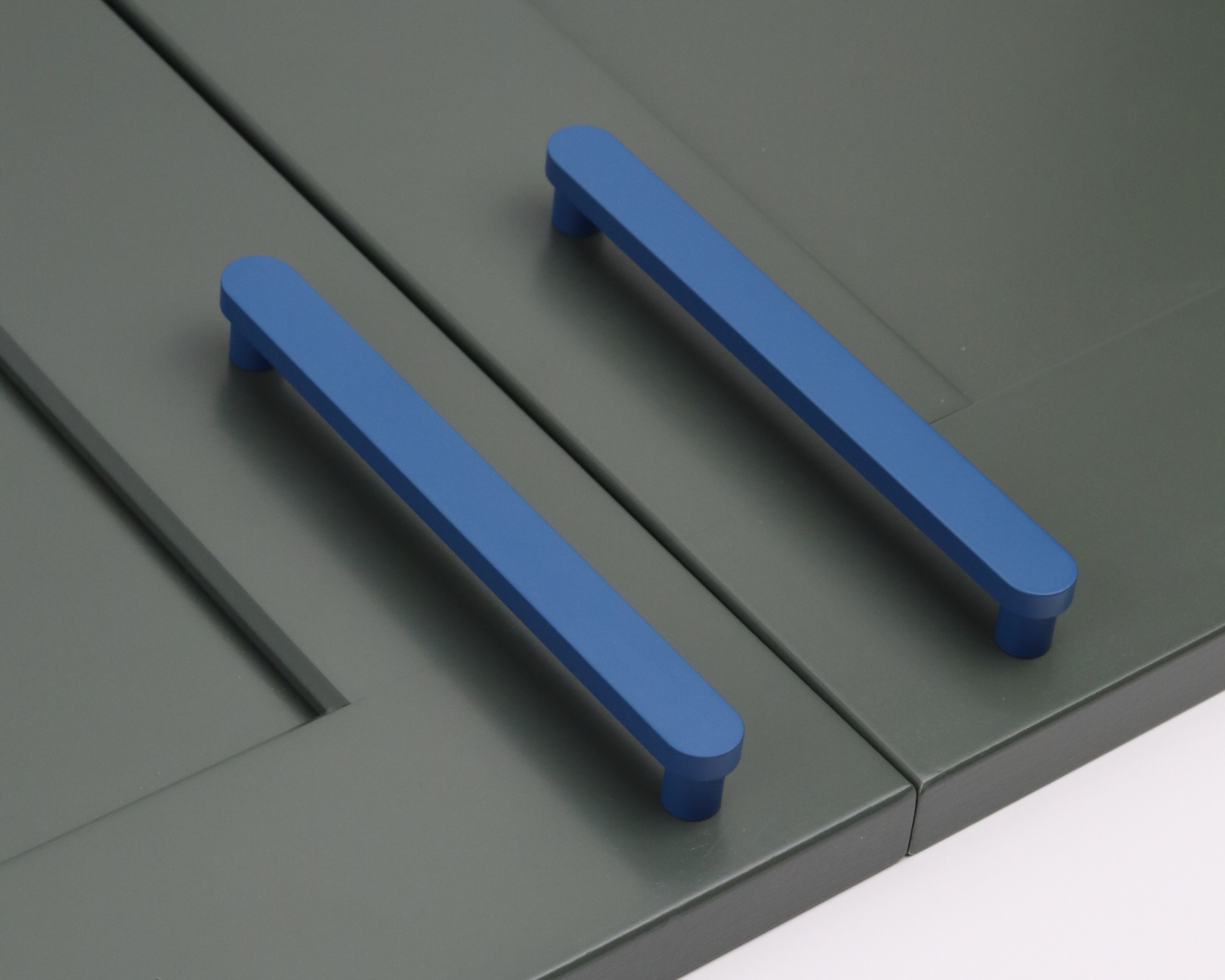 Mid-century modern green cabinet with matte blue ROUS pulls, showcasing bold color contrast and timeless MCM design flair.